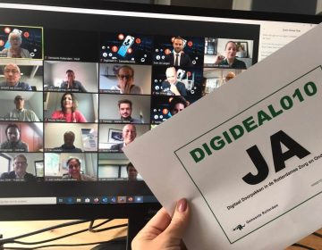 Online vergadering iemand houd een briefje omhoog met ''Digideal010 JA''