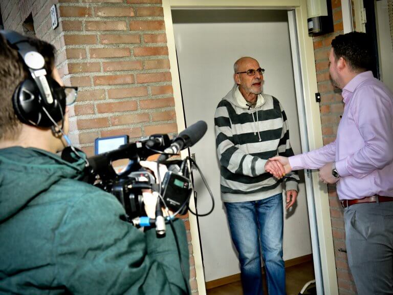 Mannen geven elkaar een handshake, filmcamera filmt