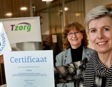 lachende vrouw houdt een certificaat omhoog